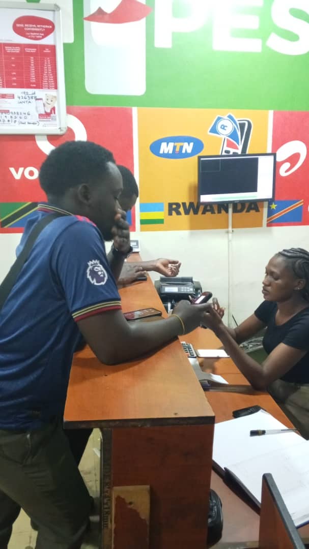 Staff member assisting a customer with a mobile money transaction